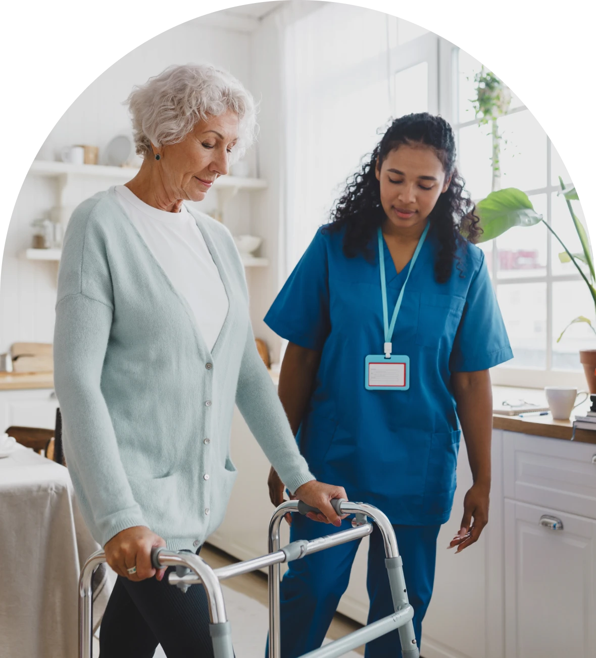 Elderly woman using walker with nurse assistance
